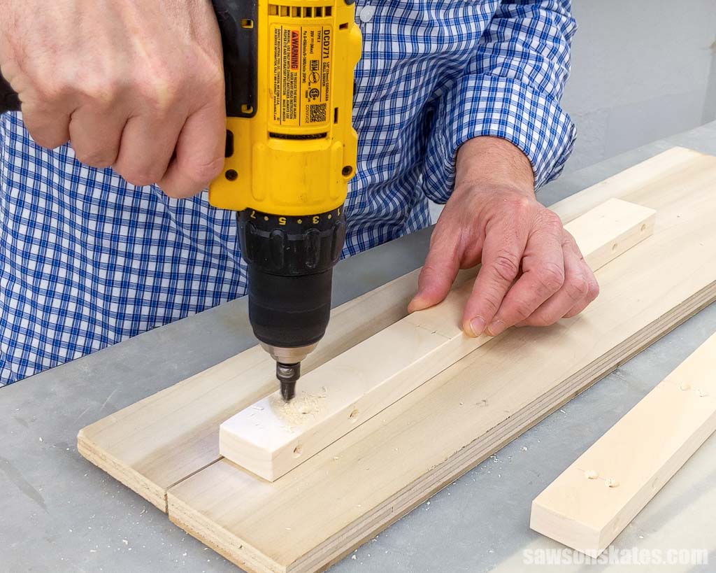 Using a drill to make countersink holes in a piece of wood