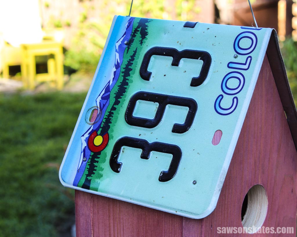 Closeup of a license plate used as a roof for a birdhouse