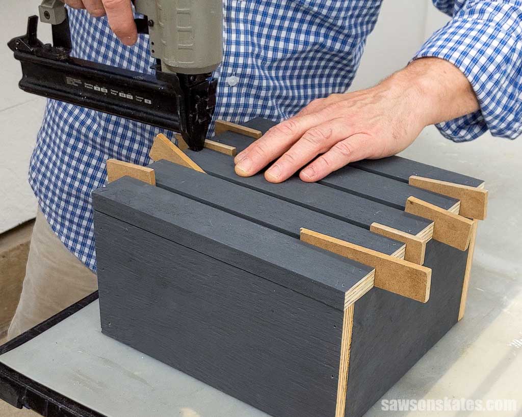 Attaching the front slats on a DIY pumpkin lantern with a brad nailer