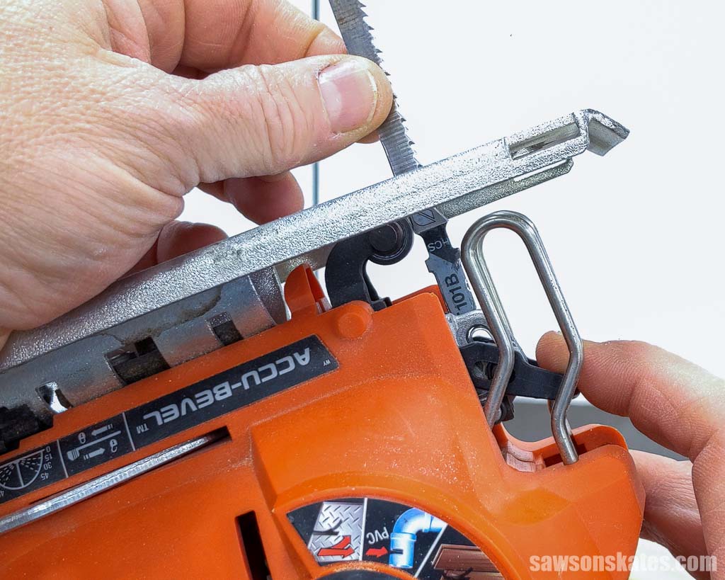 Hands inserting a t-shank blade into a jigsaw
