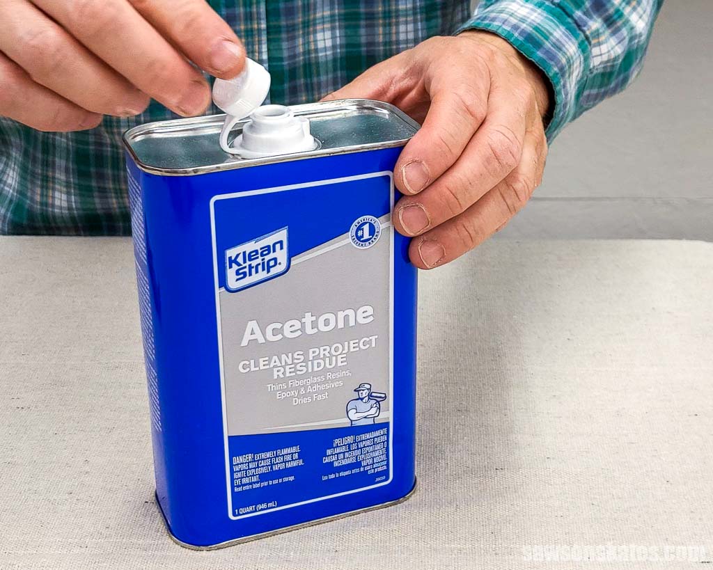 Hand opening a container of acetone