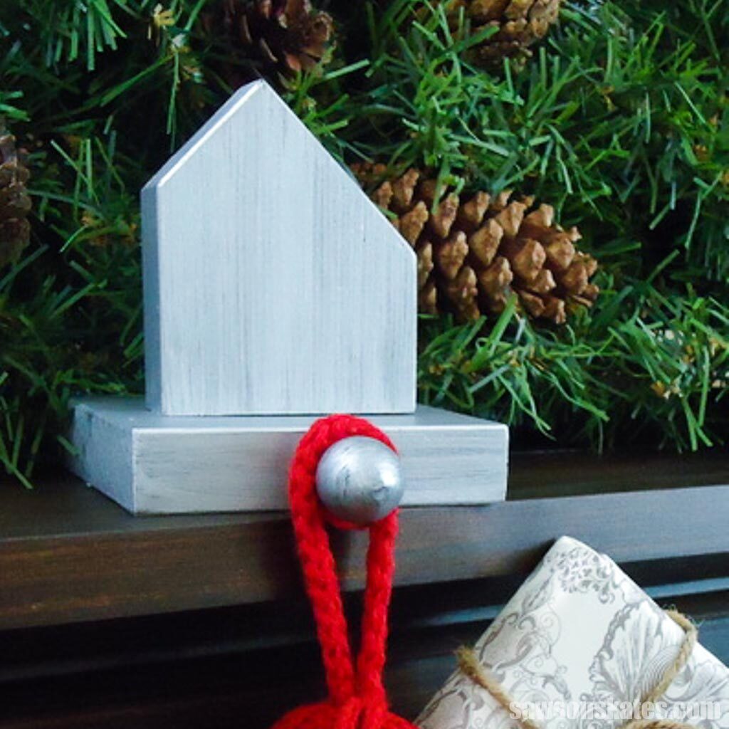 Metallic color house-shaped Christmas stocking holder on a mantel