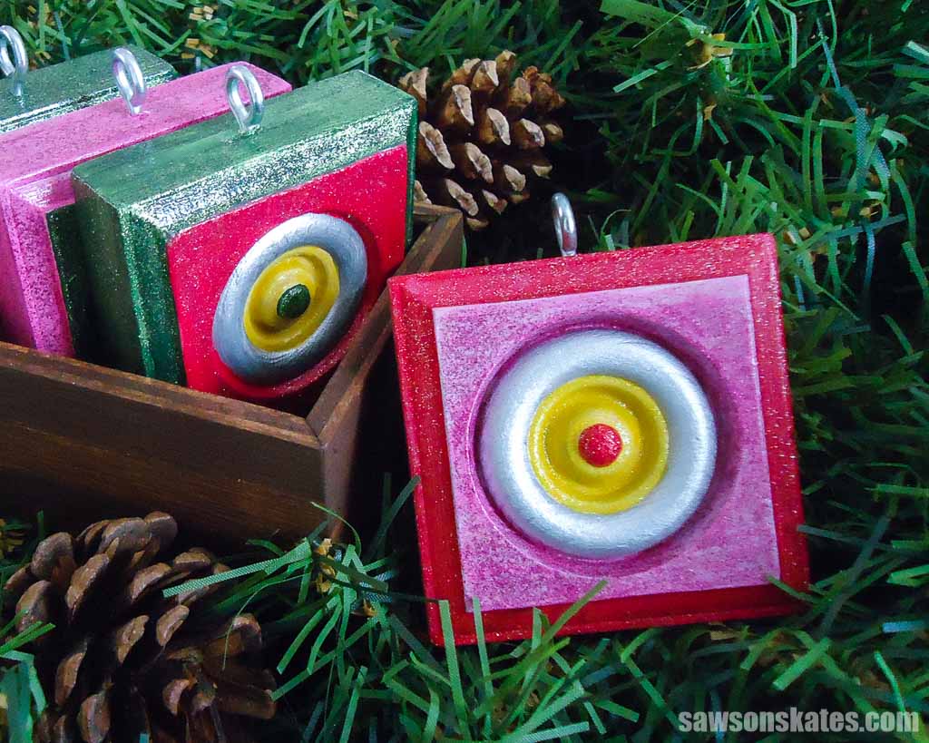 Painted wood Christmas ornament surrounded by pine needles