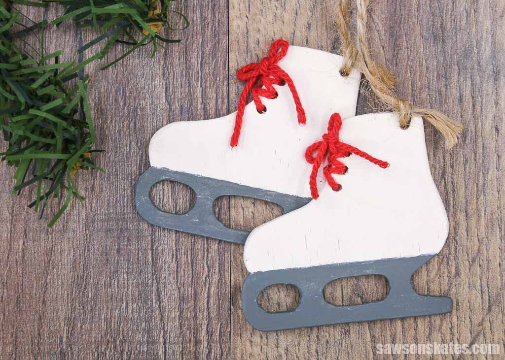 Wooden DIY ice skate ornaments on a wood background