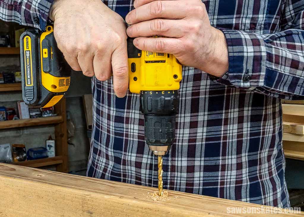 Using a drill to make a hole in piece of woodd