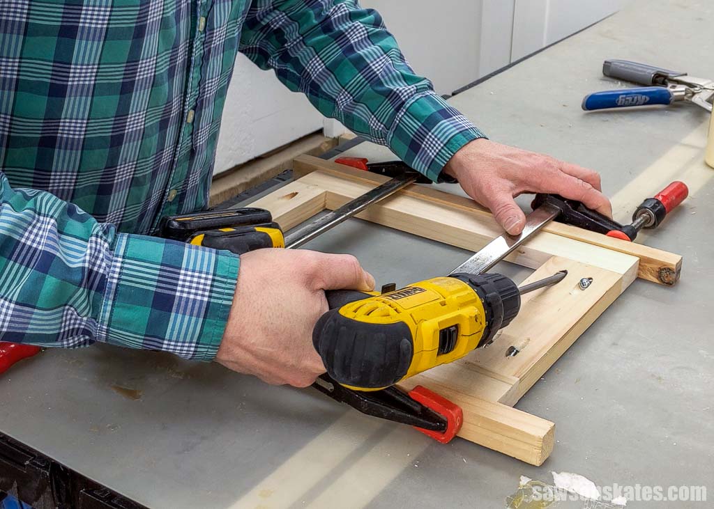 Using a drill to drive a pocket screw into  a frame