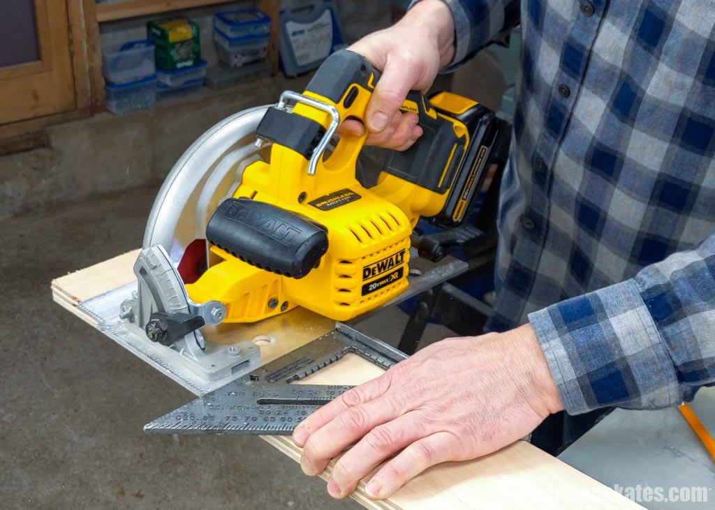 Making a crosscut with a yellow circular saw and a speed square