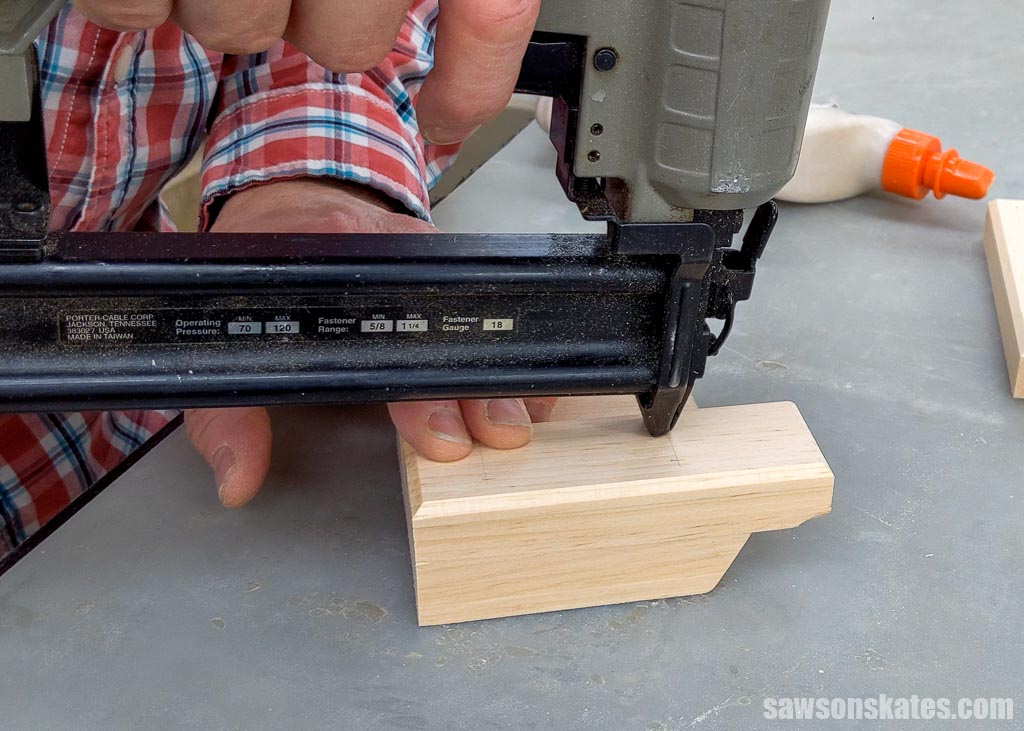 Using a brad nailer to attach the short bottom section of a DIY phone holder