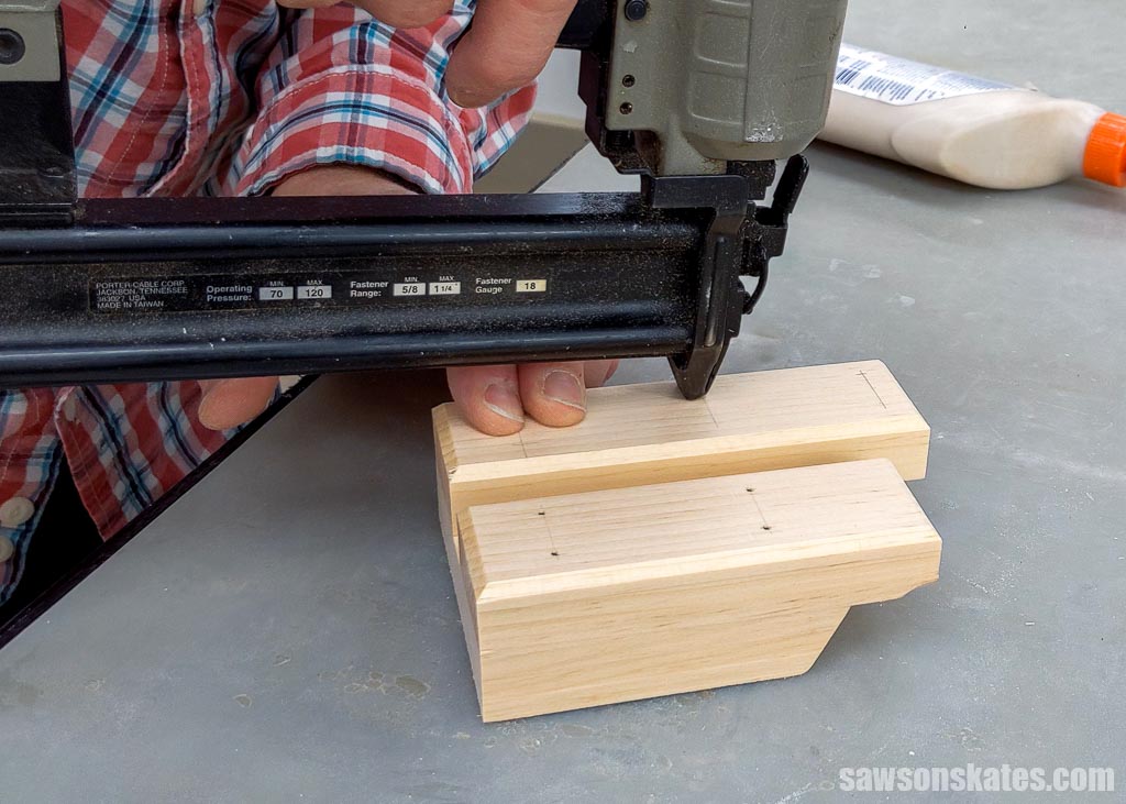 Using a brad nailer to attach the long bottom section of a DIY cell phone stand