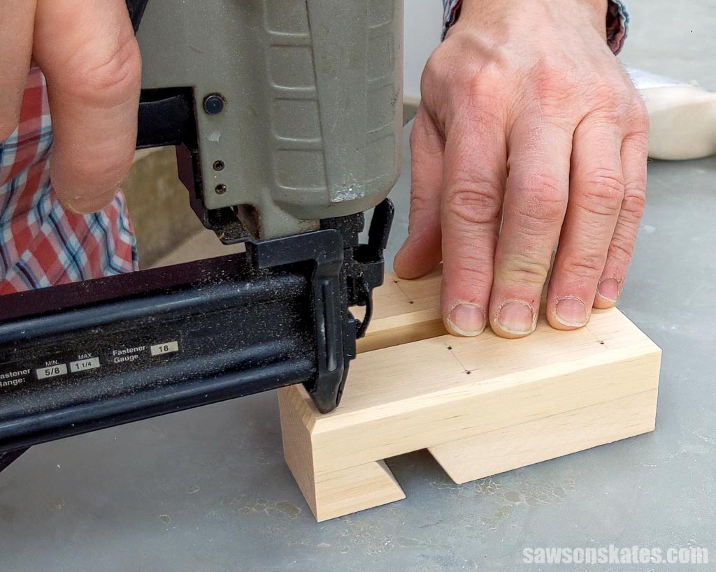 Attaching the remaining piece of a DIY phone holder with a brad nailer