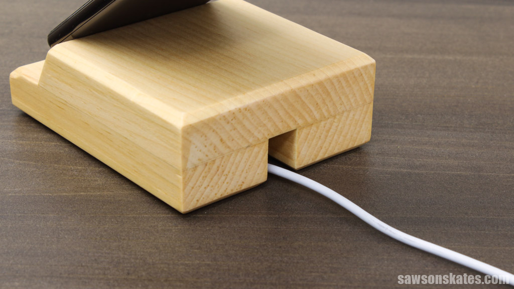 Back side of a DIY wood phone holder with charging cord