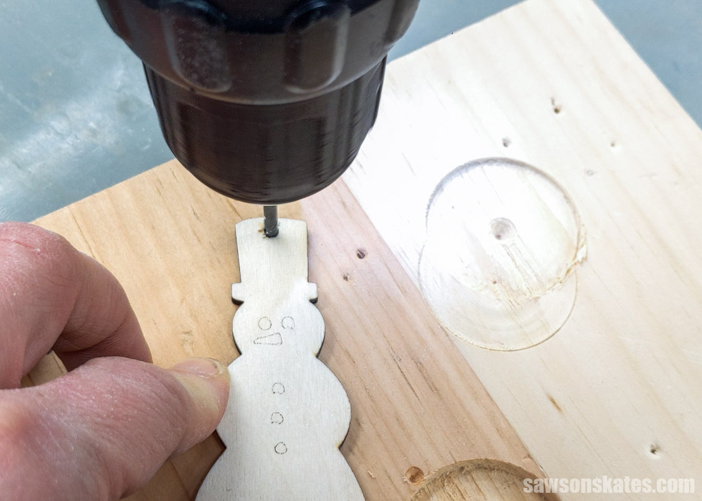 Drilling a hole for a hanger in a wood snowman ornament