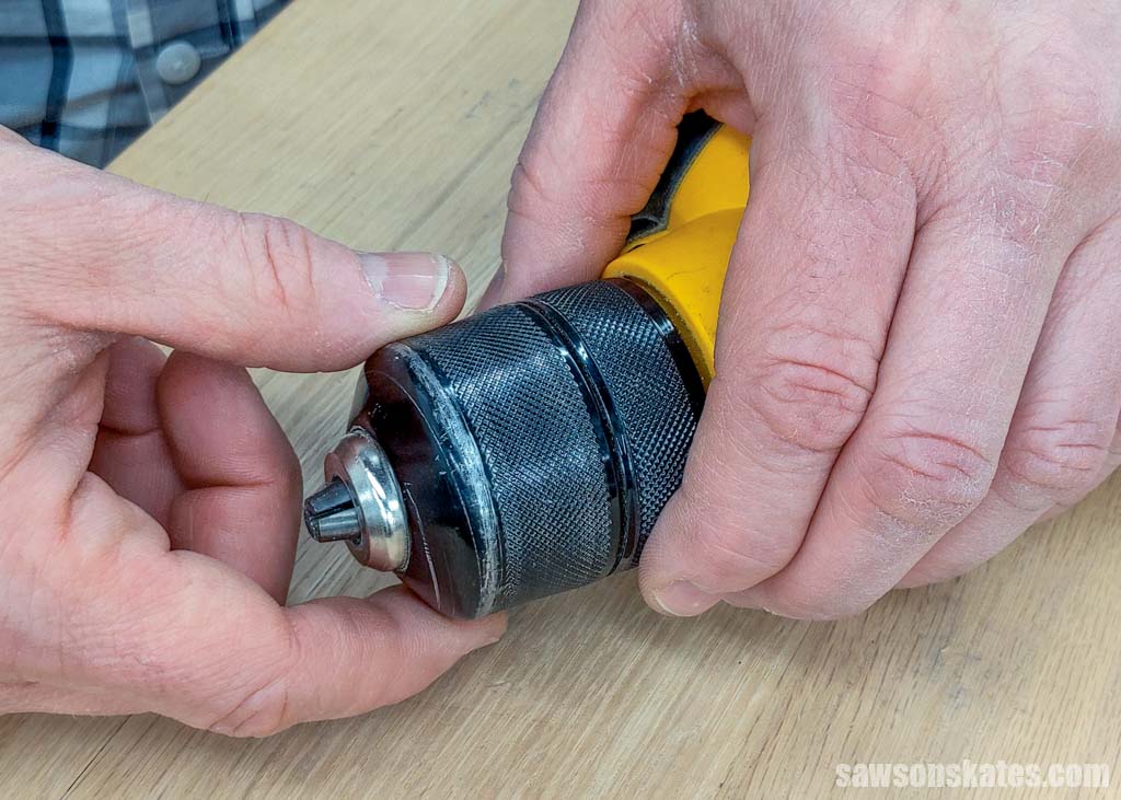 Hands opening a drill's keyless chuck to put in a drill bit