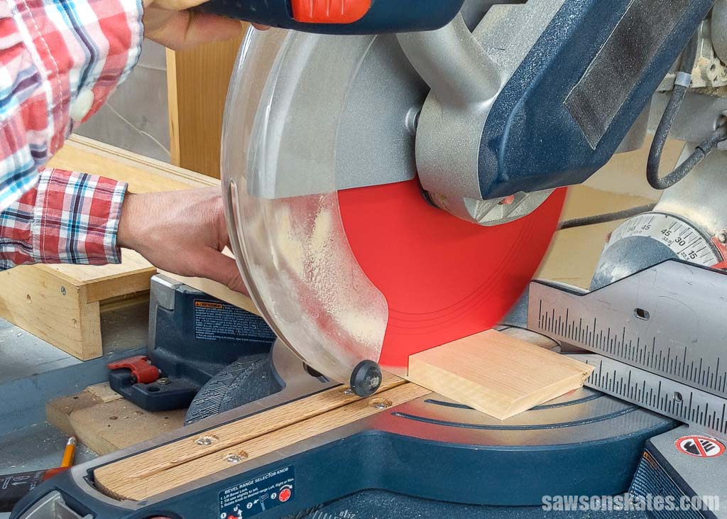 Cutting a piece of wood to length with a miter saw