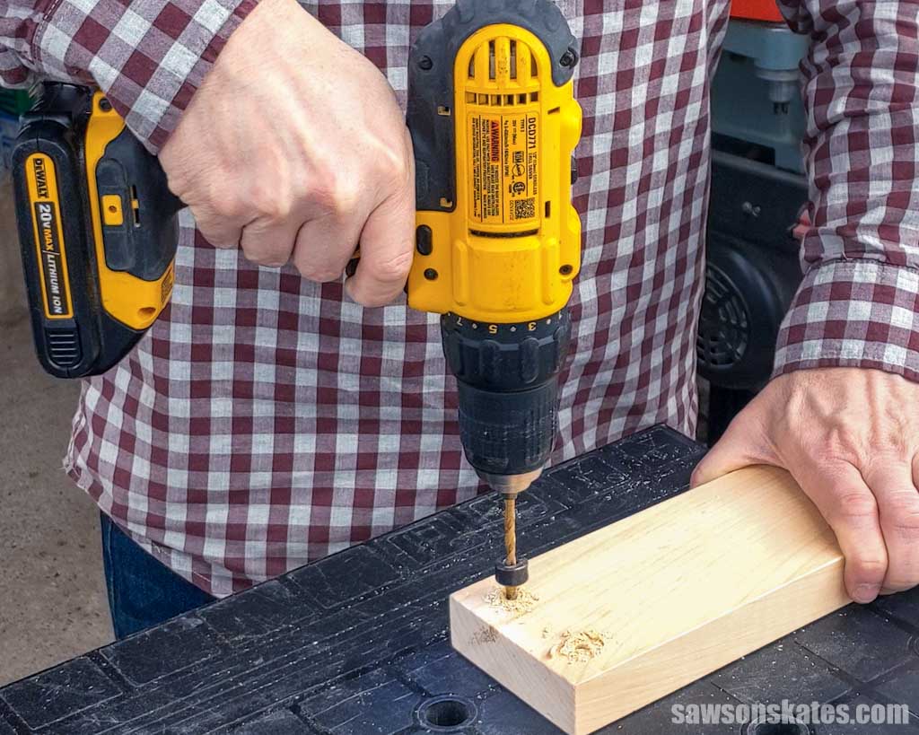 Using a drill to make a pilot hole in a piece of wood
