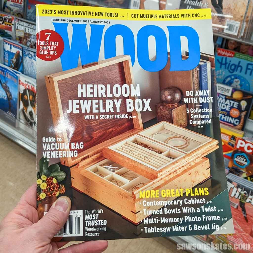 Hand holding a Wood magazine in front of a magazine rack