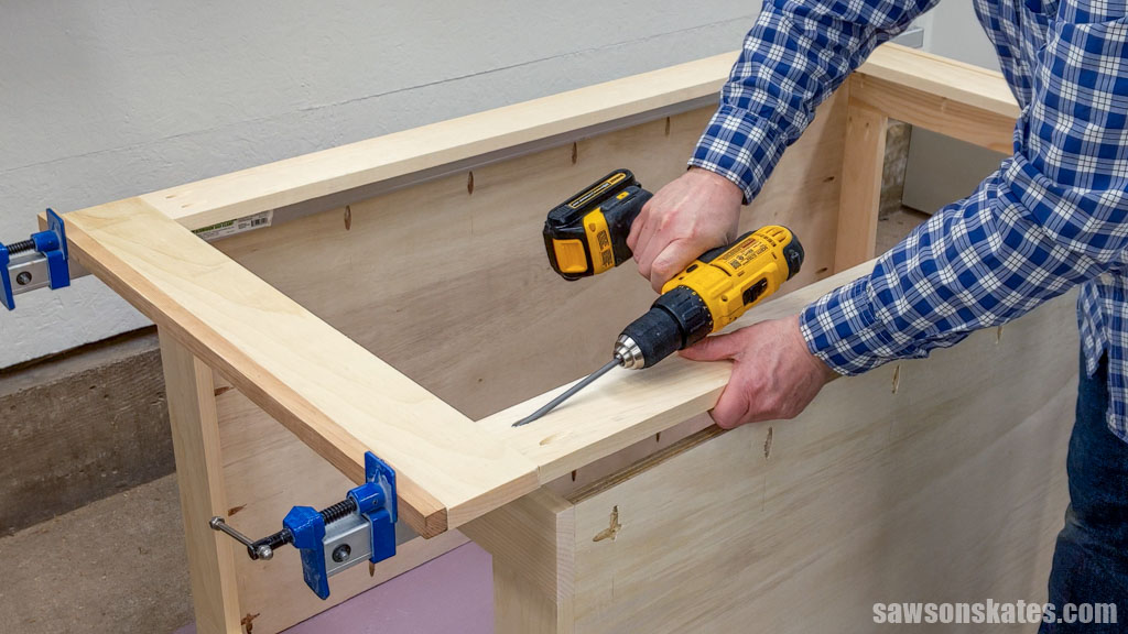 Assembling the side of a DIY utility cart using a drill and pocket holes