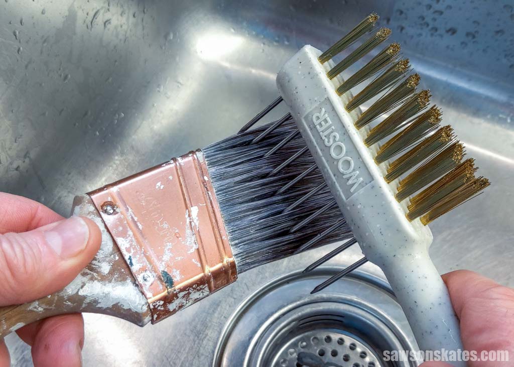 Hand using a painter's comb to straighten a paint brush's bristles