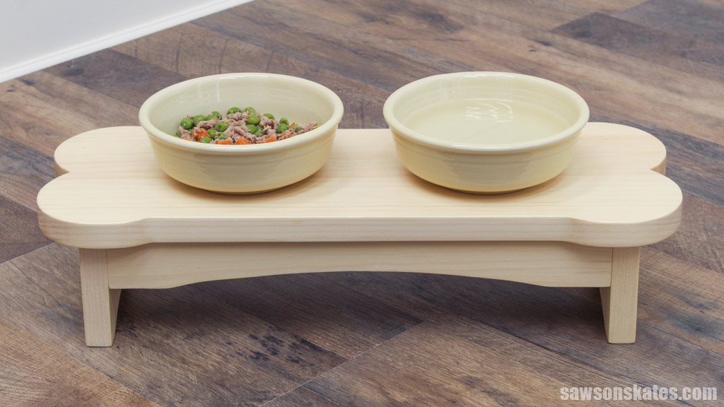Front view of a bone-shaped small dog bowl stand with two bowls filled with food and water