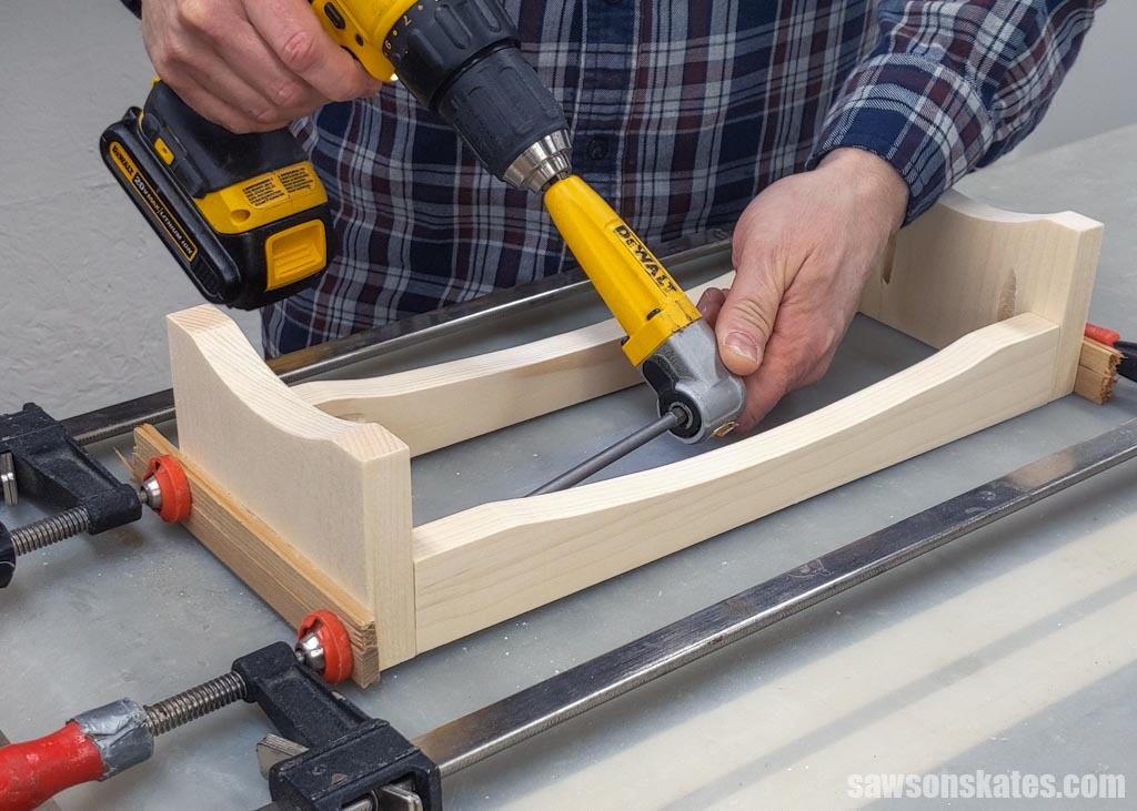 Using a drill and a right angle drill attachment to join a DIY dog bowl stand's rail to its leg