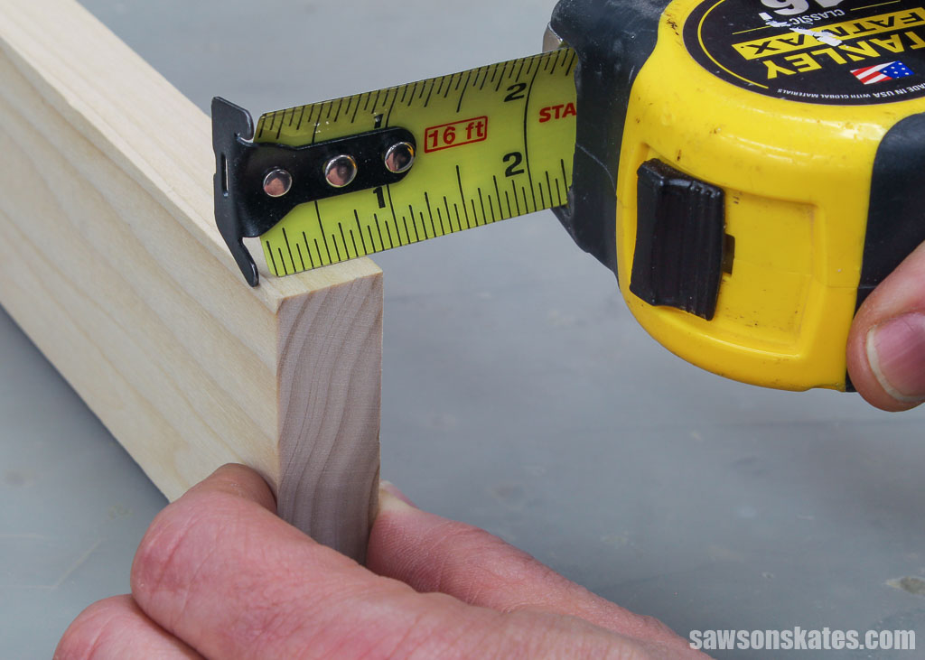 Measuring a piece of wood with a tape measure