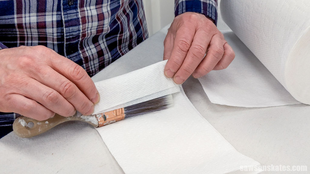Wrapping a paint brush in paper towels after cleaning it
