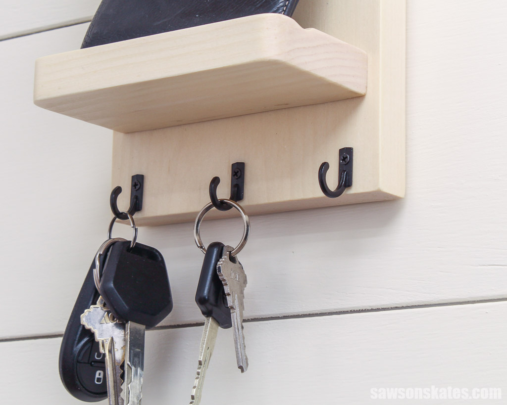 Keys hanging on hooks at the bottom of a wall-mounted DIY key holder