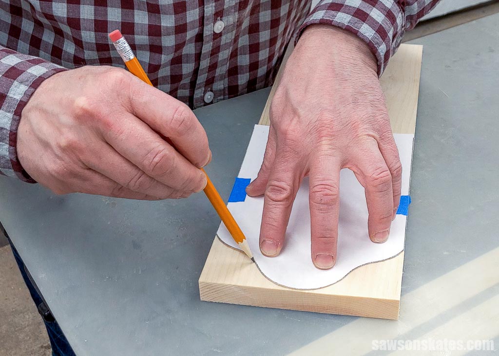 Tracing a paper template onto a board with a pencil