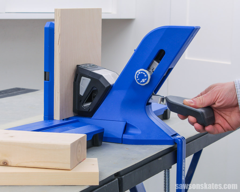 Hand pressing down on a Kreg Jig 720s clamp handle
