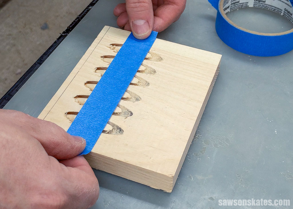 Hands applying painter's tape to a pocket hole plug bank