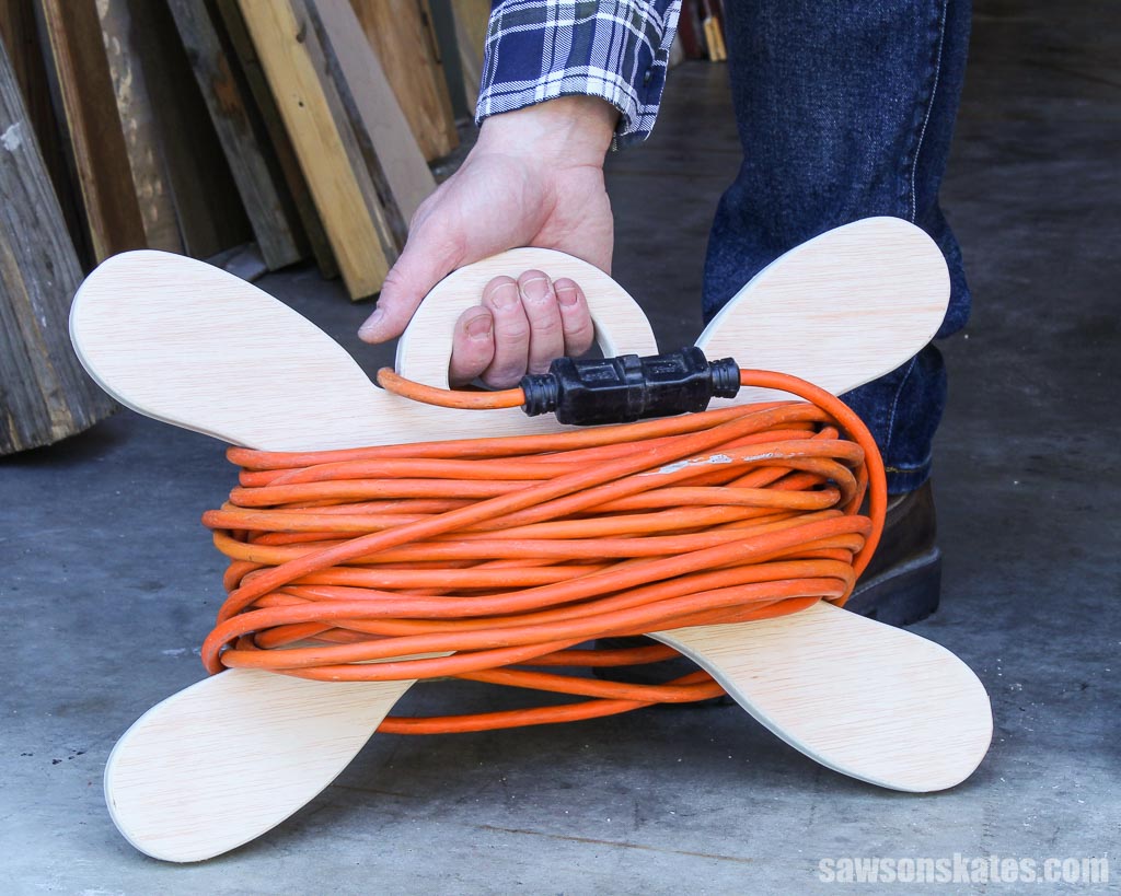Hand holding a DIY extension cord holder