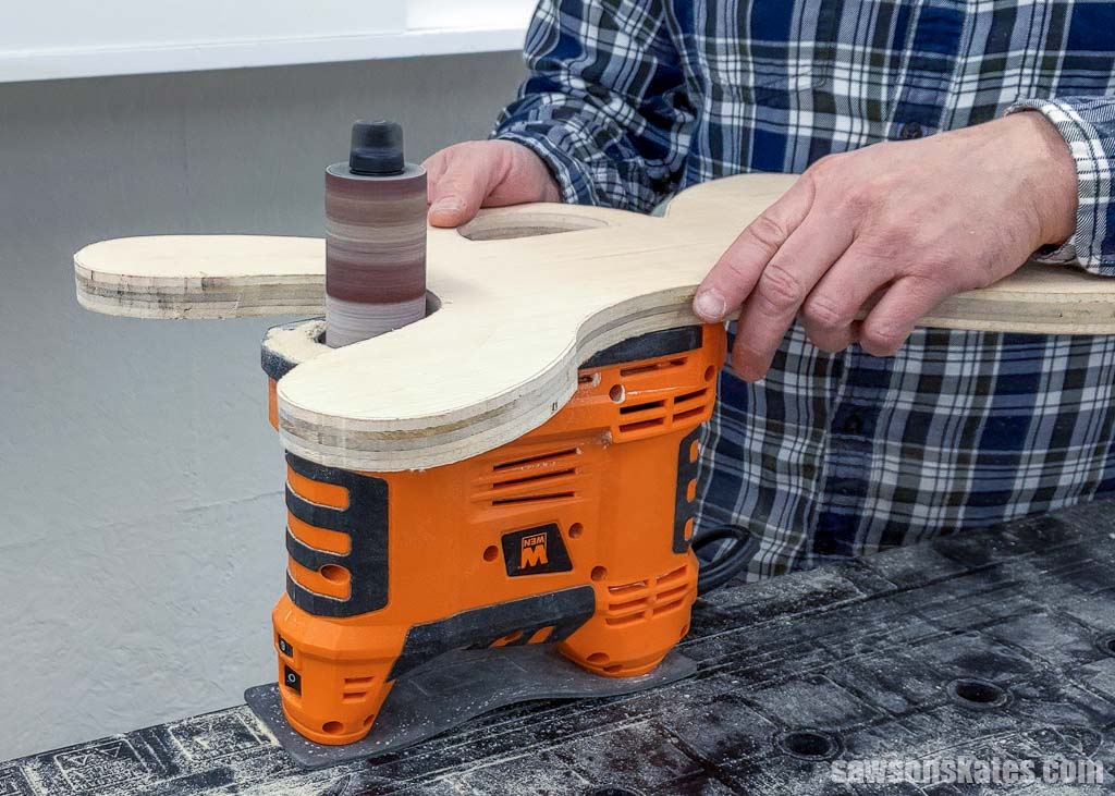 Using spindle sander to smooth a DIY extension cord holder's curves