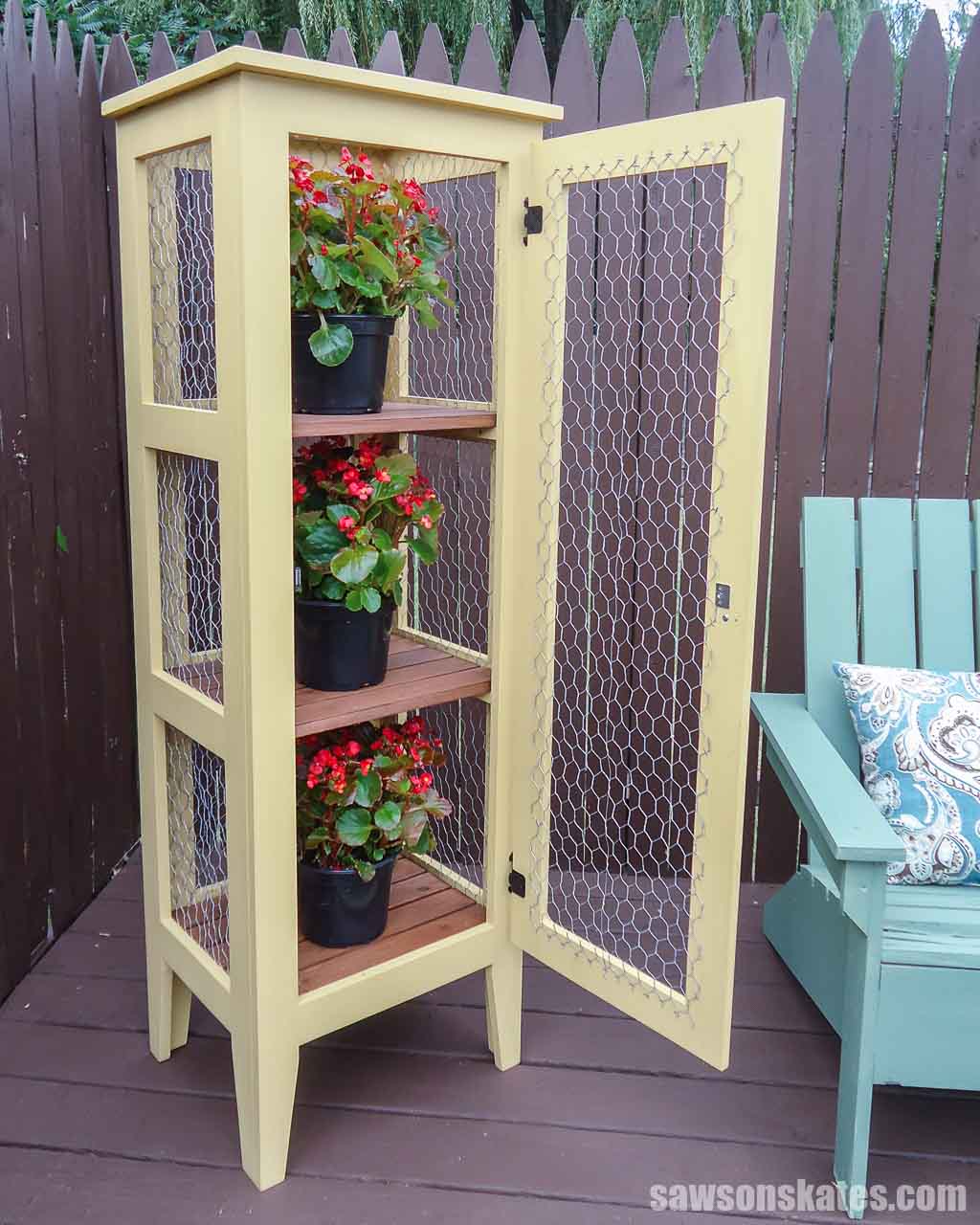DIY outdoor enclosed plant stand with its door open and a flower pot on each shelf