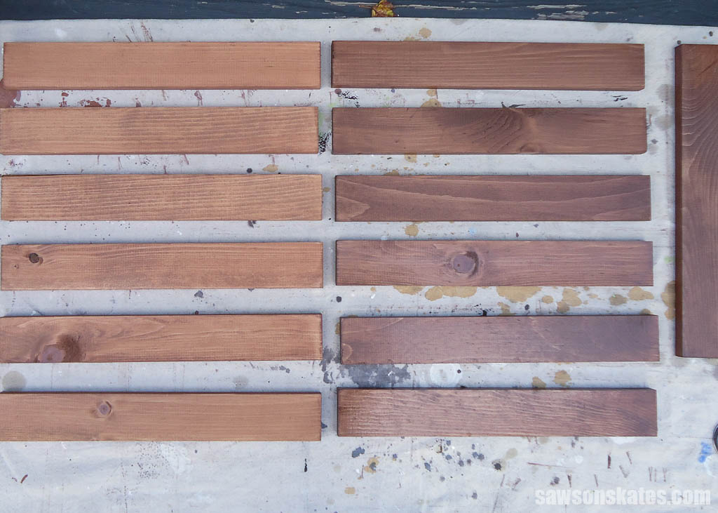 Plant shelf slats on a drop cloth after being stained