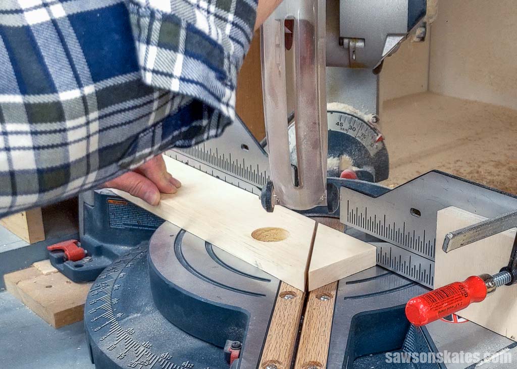 Using a miter saw to cut an angle on one side of a birdhouse's gable