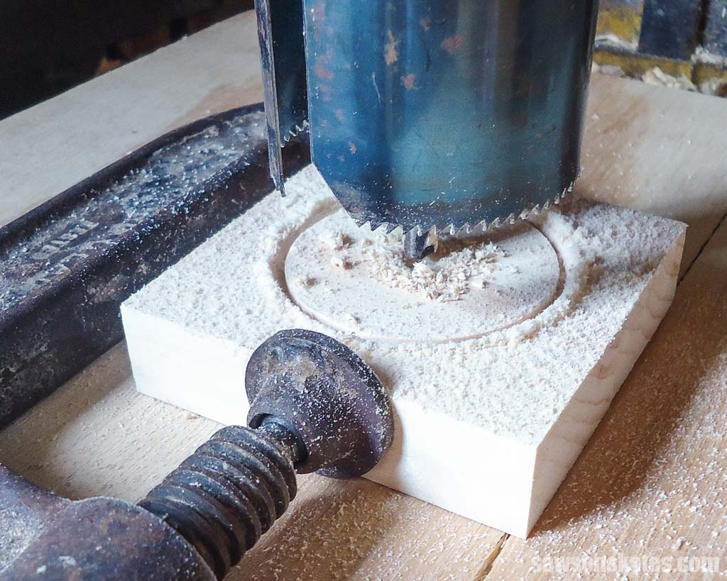 Using a drill press and a hole saw to make the tires for a DIY camper napkin holder