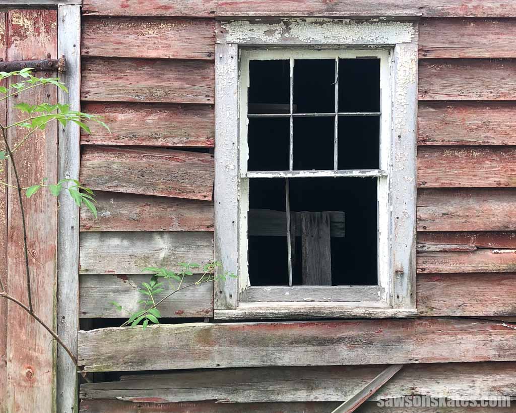 Closeup of an old barn with peeling paint and wood siding falling off