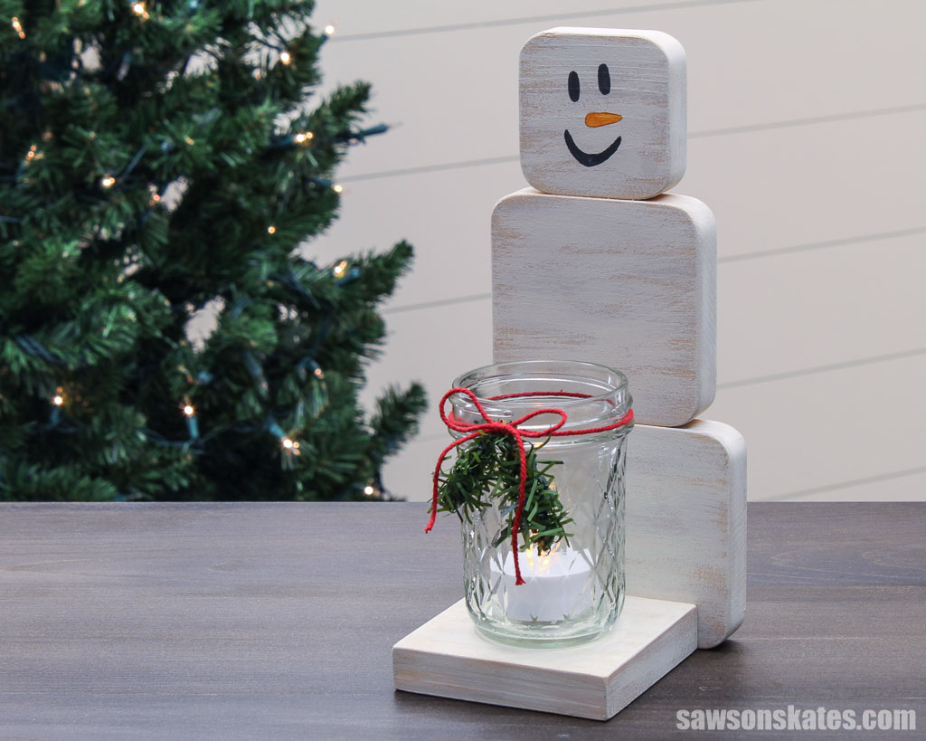 Side view of a DIY wooden snowman with a mason jar candle holder