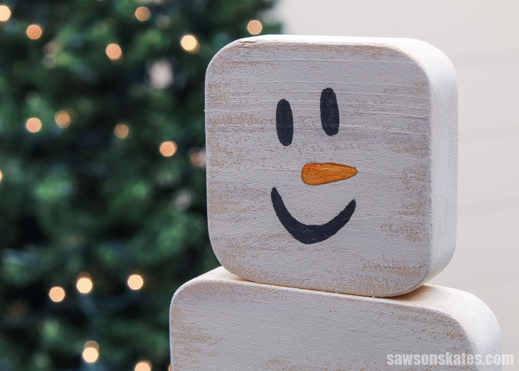 Close up of a DIY wooden snowman candle holder's face