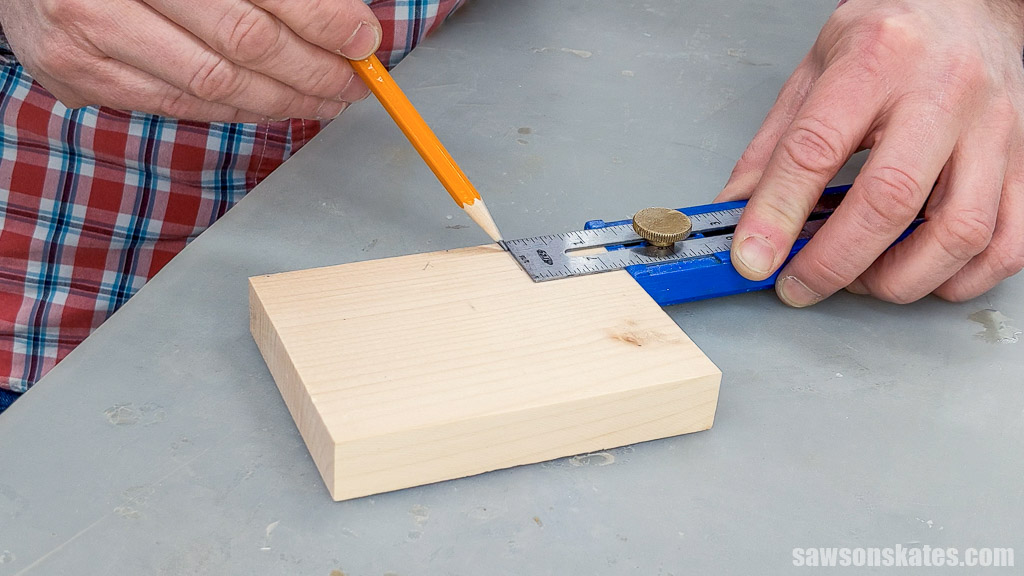 Using a pencil to mark a measurement on a piece of wood