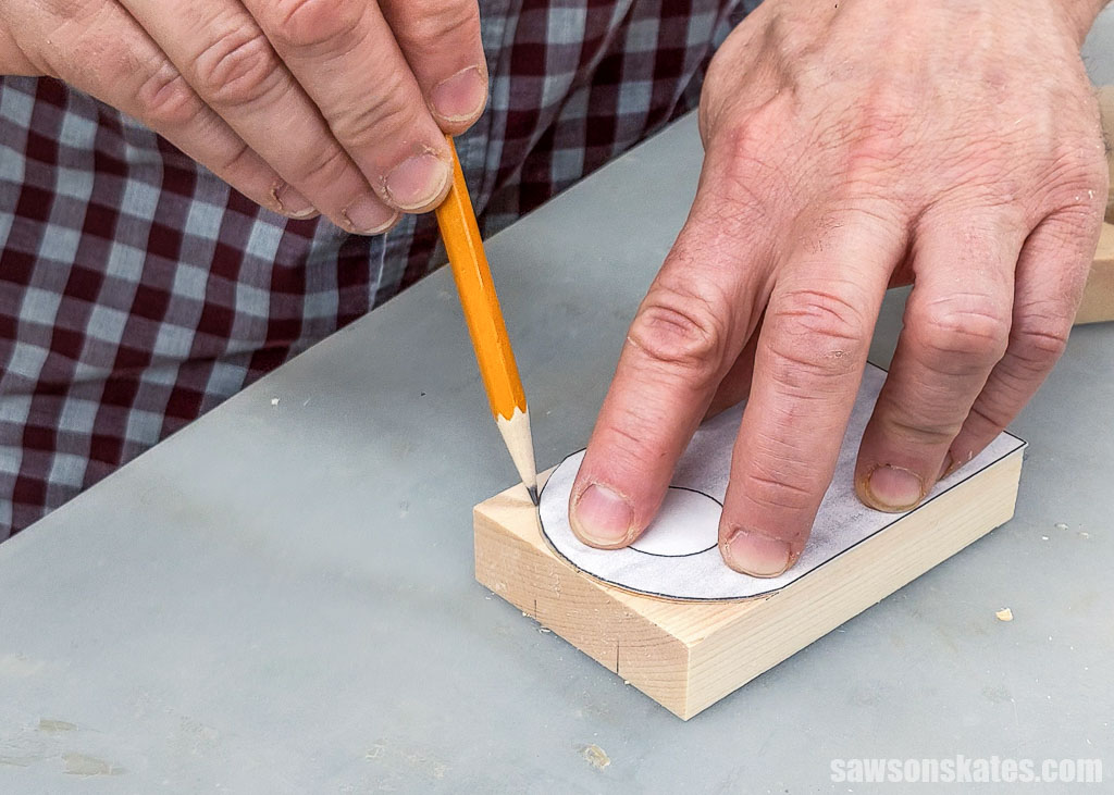 Using a pencil to trace a pattern onto a piece of wood