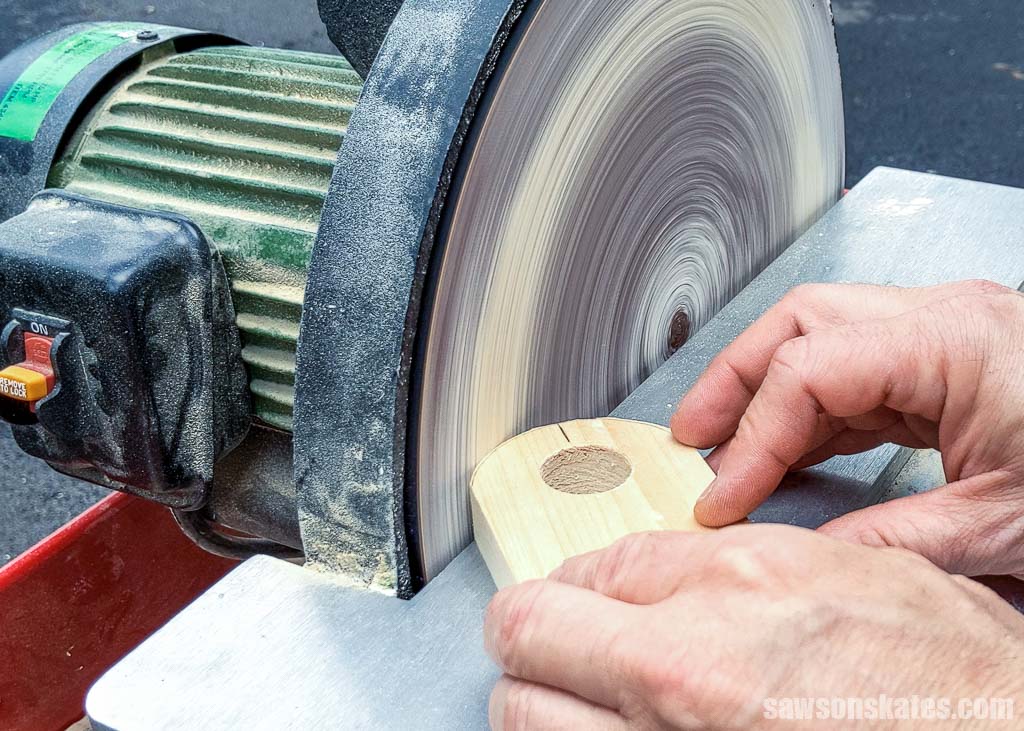 Using a disc sander to round off the corner of a board