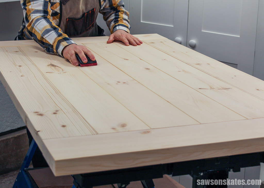 Hand sanding a simple DIY farmhouse table top