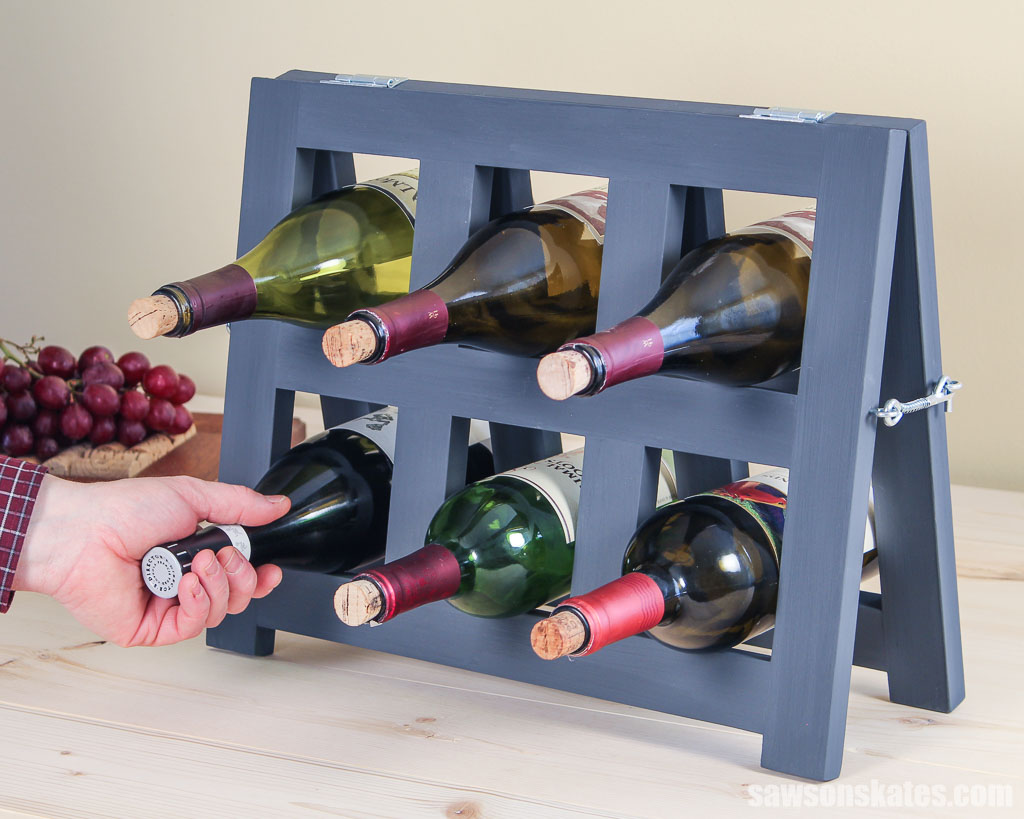 Hand removing a bottle of wine from a simple DIY wine holder