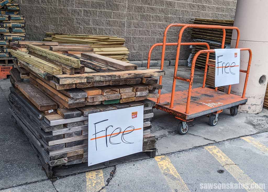 Pile of wood with a sign marked free in front of a Home Depot store