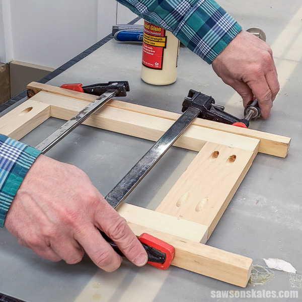 Hands tightening a bar clamp