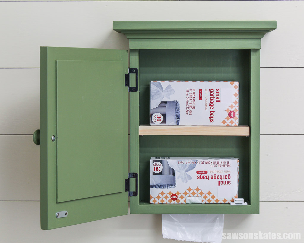 Door open on a DIY trash bag dispenser looking inside at two garbage bag boxes