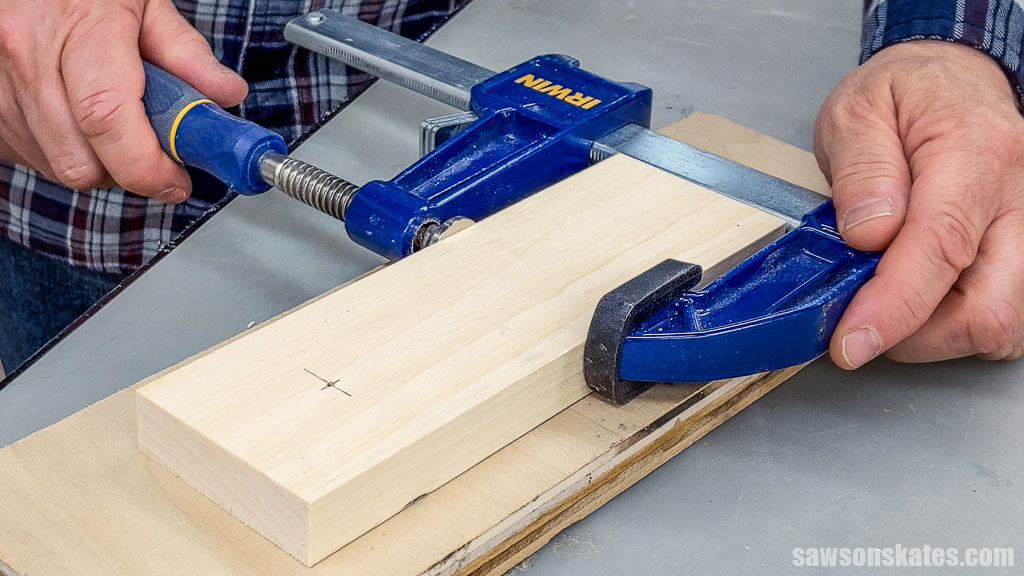 Hand tightening a clamp on a board
