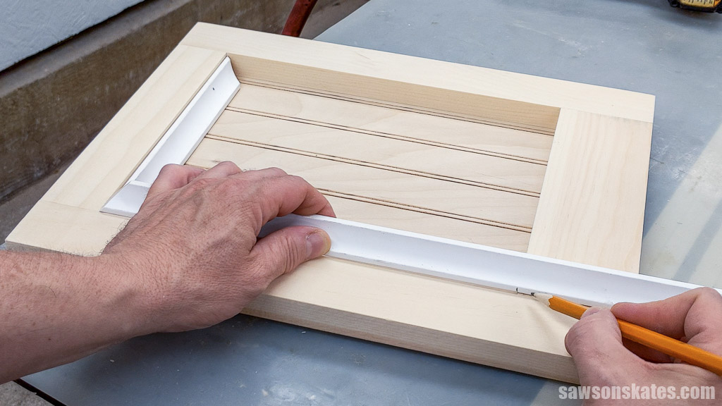 Marking the length of a second piece of cove molding for the door