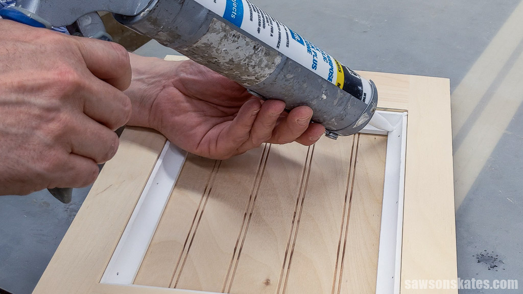 Applying caulk to the molding's gaps